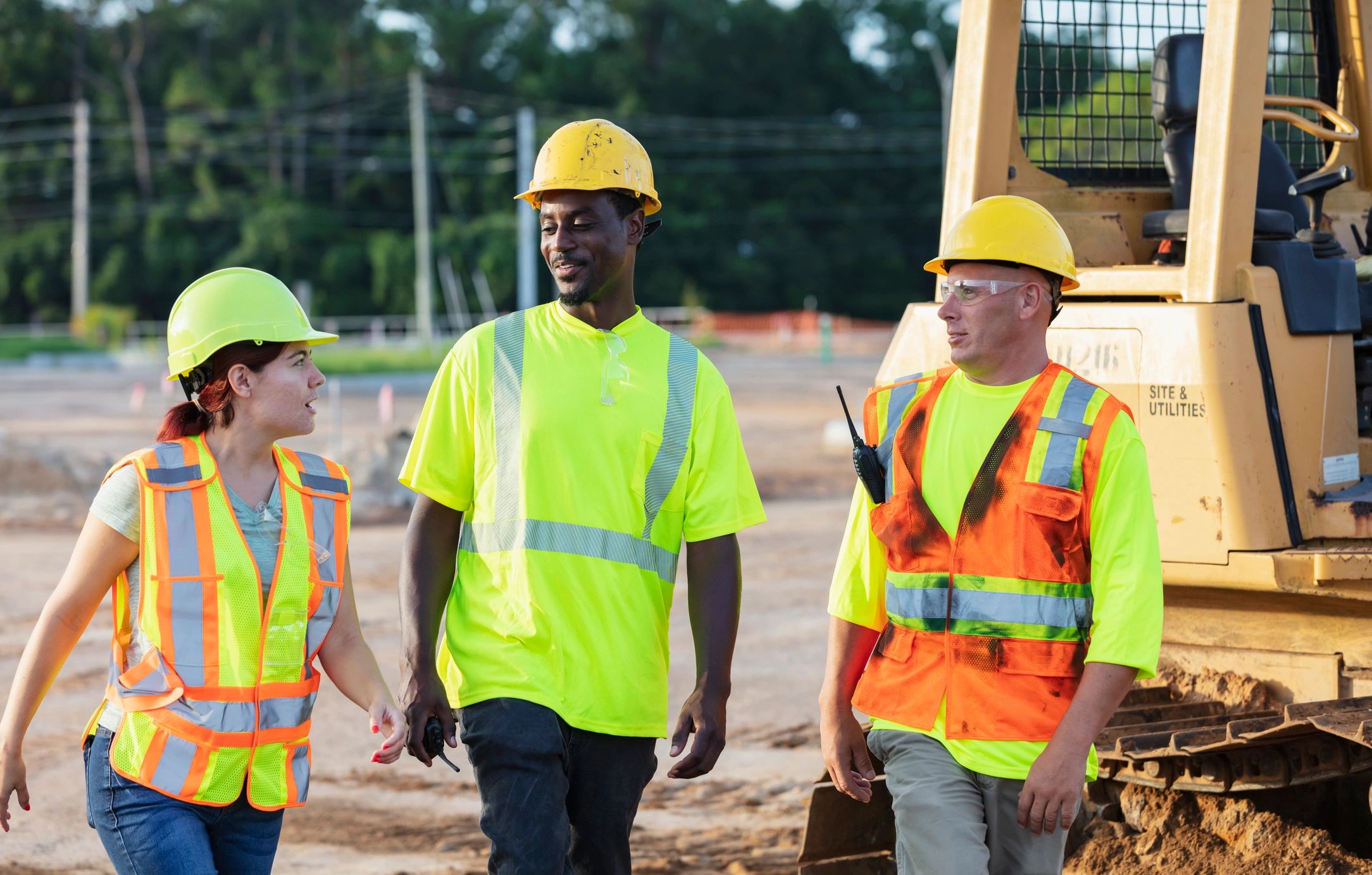 Construction professionals walking the site and discussing progress
